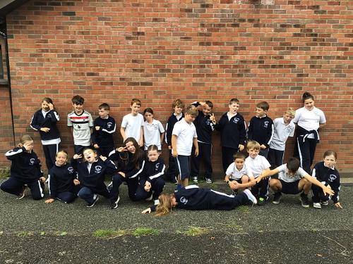 A class group photo by the school wall