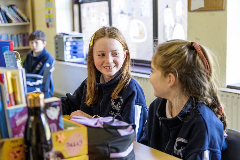 Two friends smiling at their table