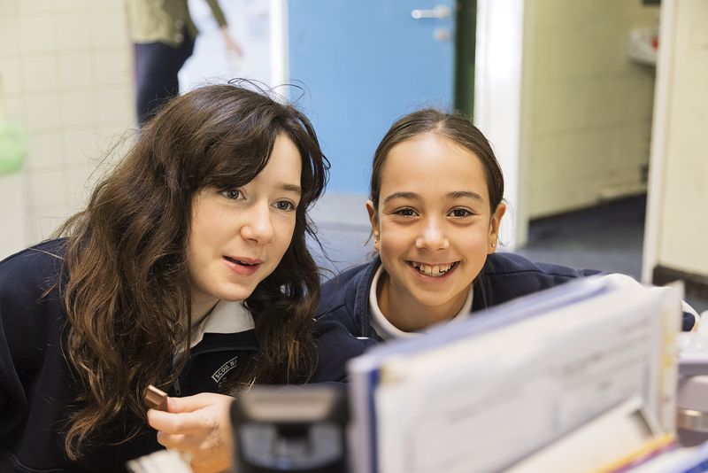 Two pupils sharing a laugh at their desk