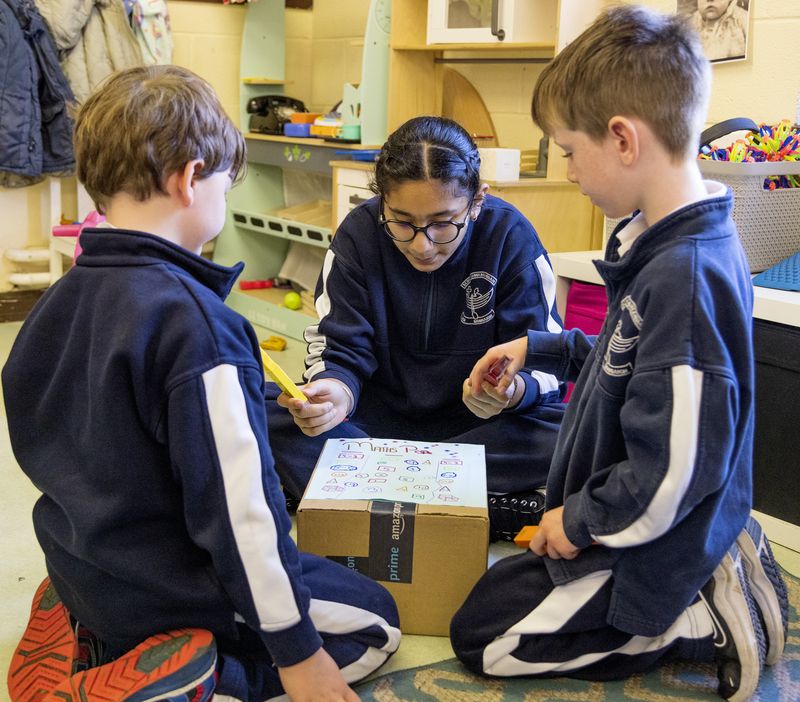 Pupils working on a project together on the floor