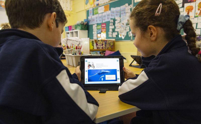 Two pupils working on a laptop