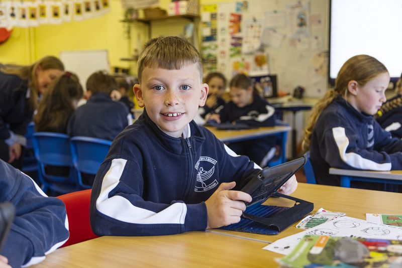 A smiling pupil working on a tablet