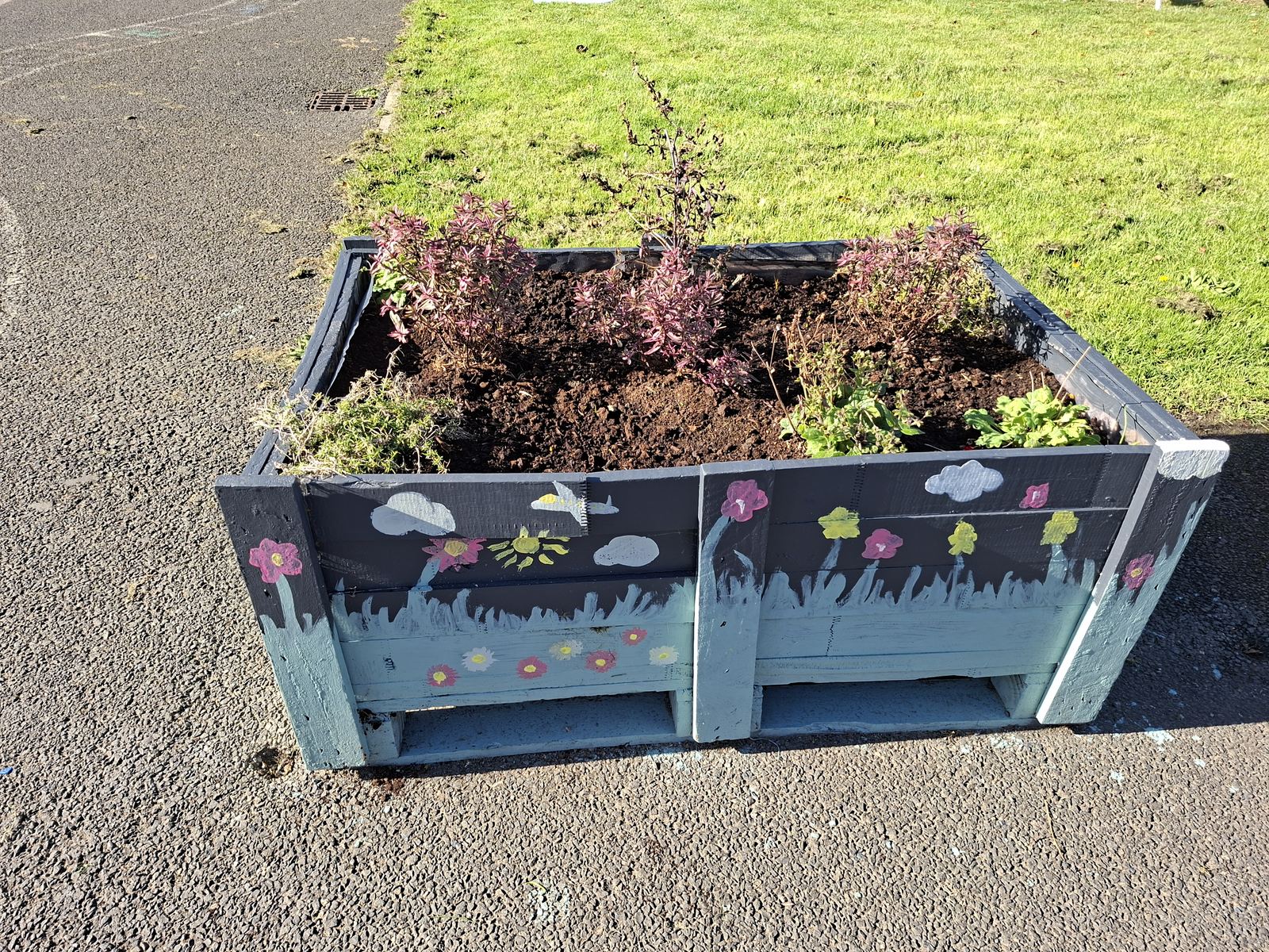 A planter upcycled and painted with flowers by our gardeners