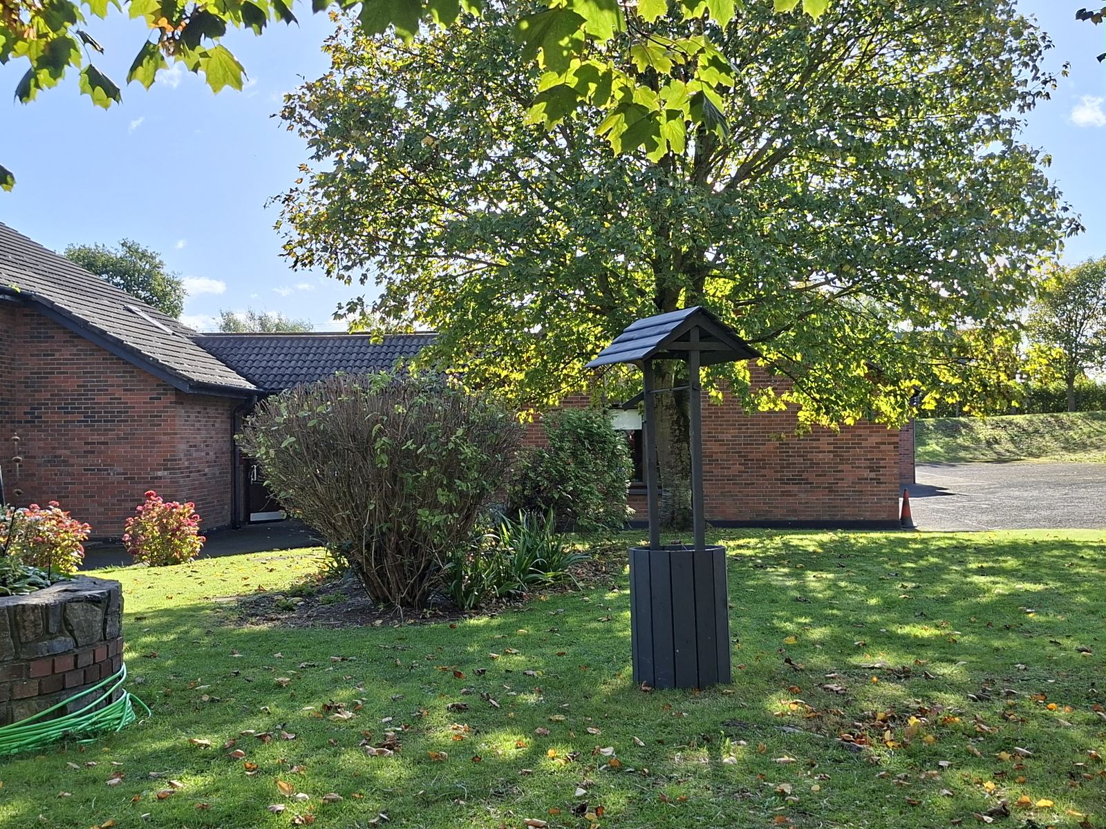 The school gardens and wishing well under the trees